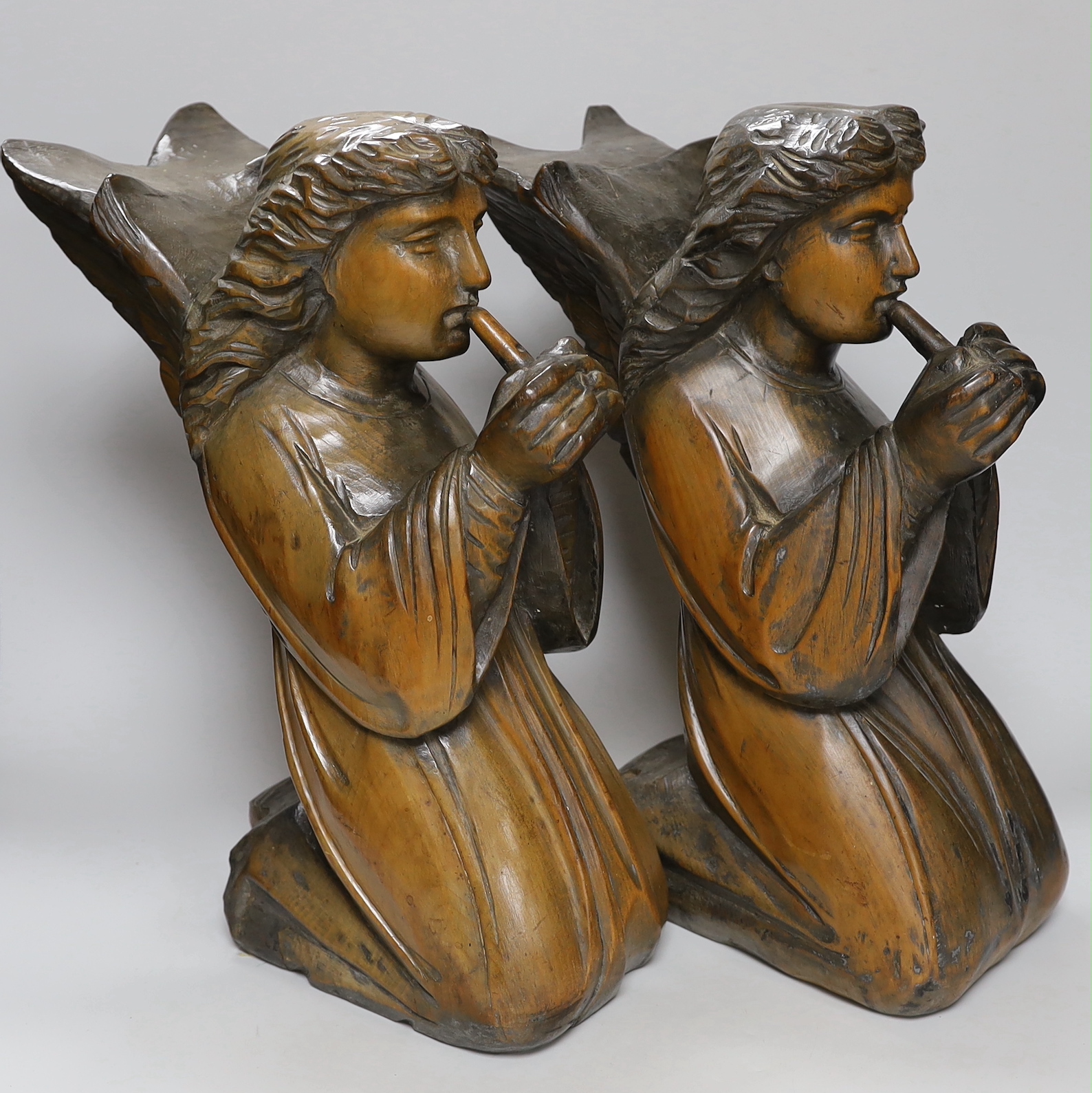 A pair of carved pine angels playing recorders, height 40cm